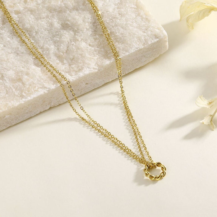 Collier double chaîne dorée reliée par un anneau ondulé